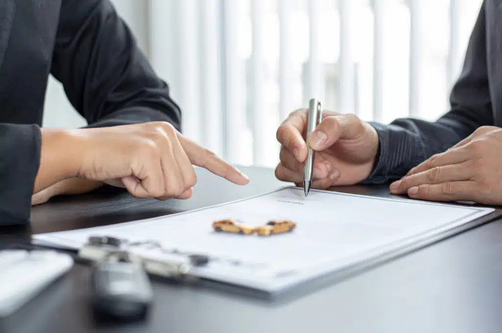 two people pointing at and writing on a paper with a graph